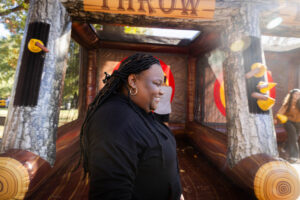 A female student smiles while walking by a giant inflatable during Fall Fest