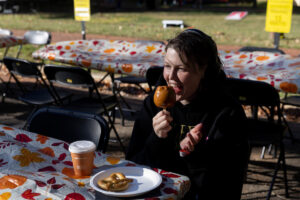 A female student gets ready to bit into a candy apple