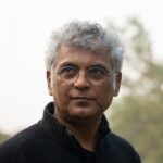 A close-up photo of a man wearing glasses