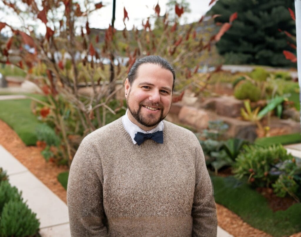 A photo of a man wearing a sweater and bow tie
