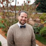 A photo of a man wearing a sweater and bow tie A photo of a man wearing a sweater and bow tie