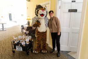 A woman poses for a photo with Wanda WildCat, dressed up as Cruella De Ville for Halloween
