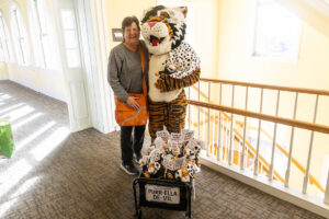 A woman poses for a photo with Wanda WildCat, dressed up as Cruella De Ville for Halloween