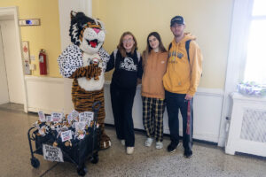 Students pose for a picture with the Wanda WildCat mascot, dressed up as Cruelle De Ville for Halloween