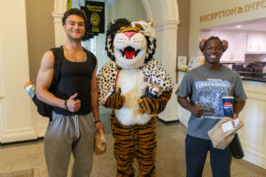 Students pose for a picture with the Wanda WildCat mascot, dressed up as Cruelle De Ville for Halloween