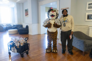 A student poses for a picture with the Wanda WildCat mascot, dressed up as Cruelle De Ville for Halloween