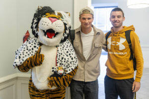 Students pose for a picture with the Wanda WildCat mascot, dressed up as Cruelle De Ville for Halloween