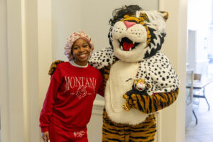 A student poses for a picture with the Wanda WildCat mascot, dressed up as Cruelle De Ville for Halloween