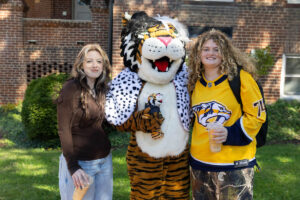 Students pose for a picture with the Wanda WildCat mascot, dressed up as Cruelle De Ville for Halloween