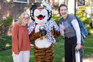 Students pose for a picture with the Wanda WildCat mascot, dressed up as Cruelle De Ville for Halloween