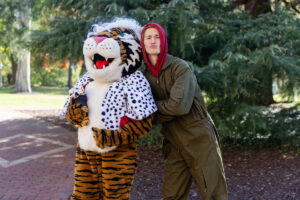 A student poses for a picture with the Wanda WildCat mascot, dressed up as Cruelle De Ville for Halloween