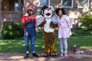 Students--one dressed as Super Mario and the other as Princess Peach-- pose for a picture with the Wanda WildCat mascot, dressed up as Cruelle De Ville for Halloween