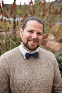 A photo of a man wearing a sweater and bow tie 