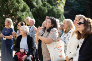 People in a crowd clap their hands