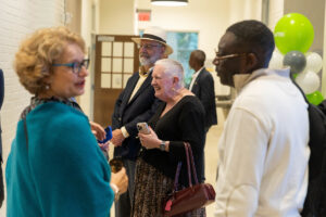 A group of people talk in the entryway of a building
