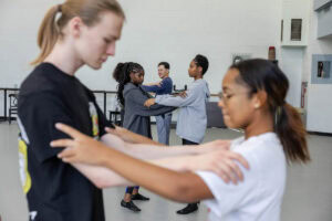 Two students practice a dance move during a tango class