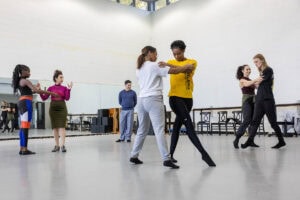 Students practice a dance move during a tango class