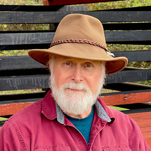 A photo of a man in a tan hat and red collared shirt