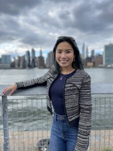 A woman poses with a city skyline in the background