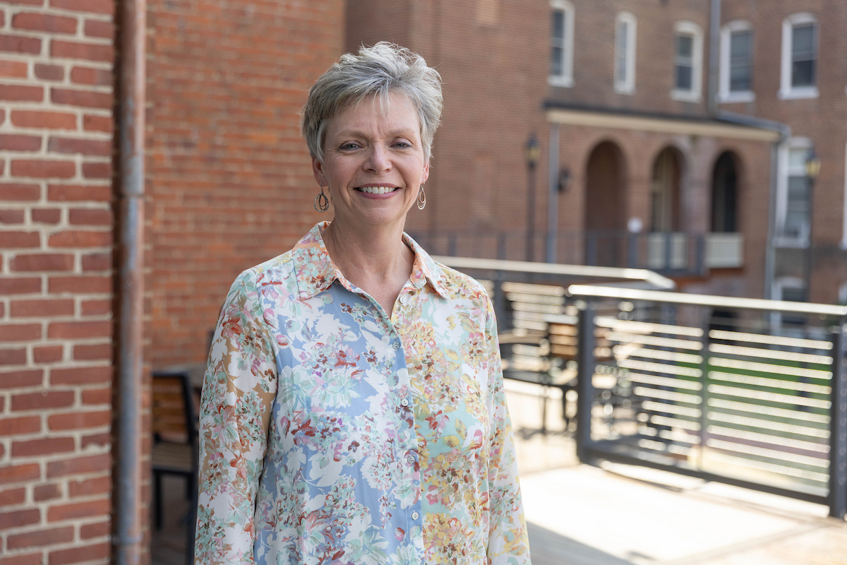 Melissa Merrill ’89 poses for a portrait outside on the Hampson Commons deck
