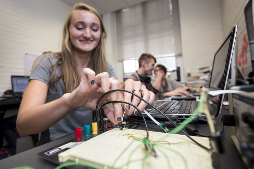 Student wires sensor configurations on her summer research project.