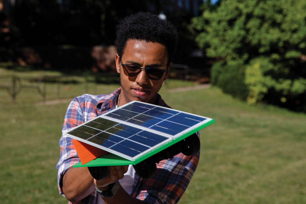 Randolph College student tests solar panel configurations on a model car.